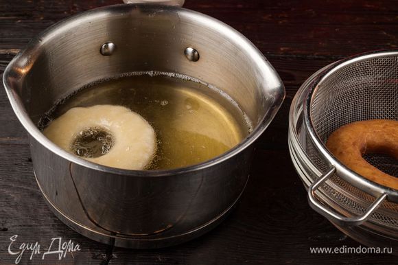 Налейте растительное масло в сотейник и выкладывайте в кипящее масло пончики. Положите готовые изделия на сито для стекания лишнего жира.