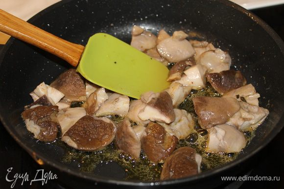 В ароматное масло положите нарезанные грибы и обжаривайте до красивой румяной корочки. Посолите, добавьте немного черного перца, влейте бульон и готовьте еще пару минут.