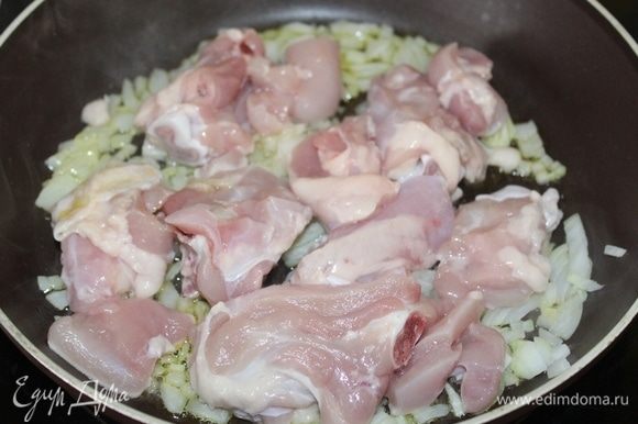 Разогреть на сковороде оливковое масло, поместить туда мелко порезанный лук и кусочки курицы.