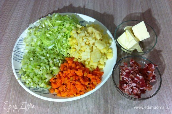 Нарезать мелким кубиком овощи: сельдерей, морковь и картофель. Тонко нашинковать полукольцами лук-порей. Нарезать небольшими кубиками бекон.