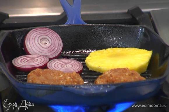 Красный лук и кольца ананаса обжарить со всех сторон на той же сковороде, что и котлеты.