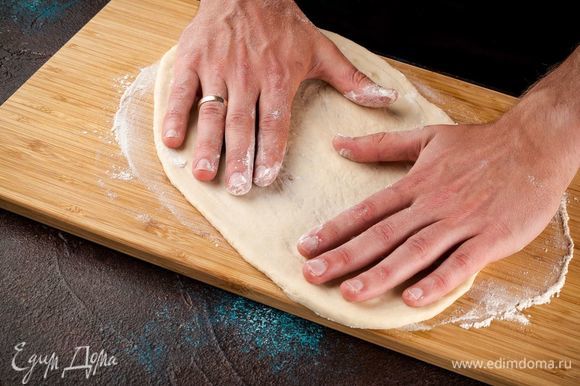 Когда тесто поднимется, вымесите его и растяните в лепешку толщиной 7 мм. Лучше тесто растянуть руками, а не раскатывать скалкой.