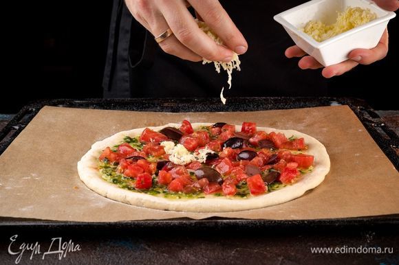 Нарежьте оливки на половинки, моцареллу натрите на терке и разложите все на тесто равномерно.