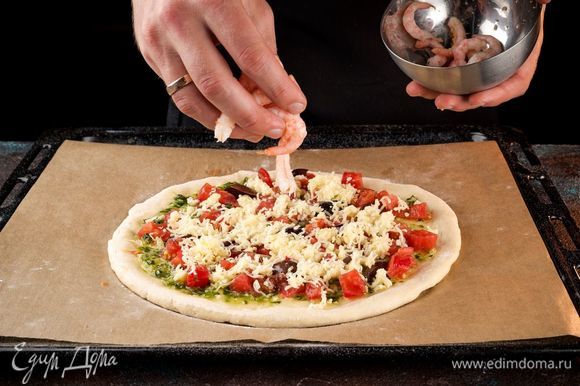 Креветки ТМ «Магуро» очистите и разложите сверху на тесто, посыпьте специями. Выпекайте пиццу 20 минут при 200°С.