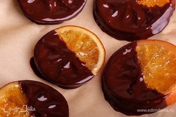 Если хотите сделать апельсины в шоколаде, то ломтики остудить, растопить некоторое количество горького шоколада, обмакнуть половинки ломтиков, остудить (при комнатной температуре).