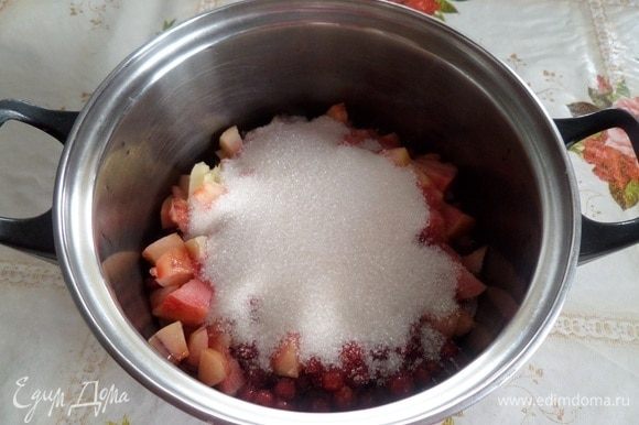 В кастрюлю выкладываем ягоды и нарезанные персики. Добавляем сахар.