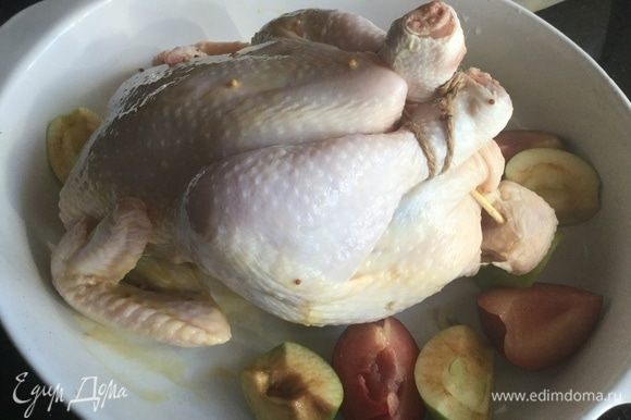 Положите курицу на спину в большую жаропрочную форму, вокруг выложите оставшиеся сливы и яблоки. Запекайте в предварительно нагретой до 180°С духовке около часа. Периодически поливайте курицу выделяющимся соком.