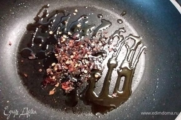 В сковороду влить 2 ст. л. кунжутного масла, добавить сычуаньский перец (у меня к сожалению произошла вынужденная замена на хлопья красной паприки).