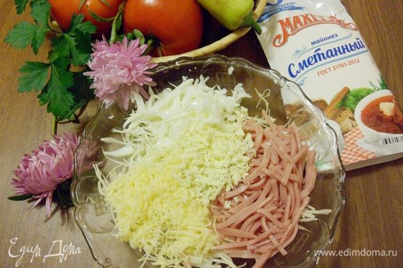 В салатник положить белокочанную капусту, ветчину, половину натертого сыра и яйца.