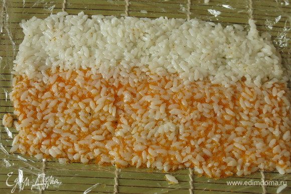 На пленку выкладываем рис цветной и белый, плотно прижимаем его, формируем коврик.