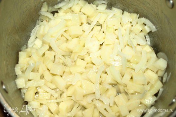 В глубокой посуде разогреть растительное масло и обжарить лук и картофель минуты 2–3.