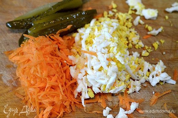 Морковь натереть на терке, яйцо отварить и натереть, соленый огурец порезать на полоски.