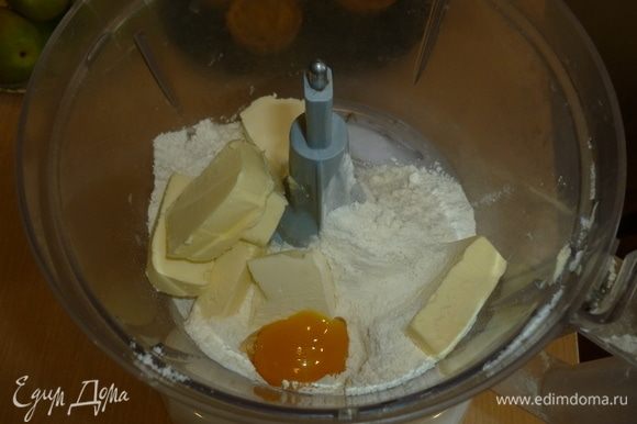 В комбайн сложить муку, добавить щепотку соли, желток и нарубить холодное масло. Прокрутить. Если тесто не собирается в комок, то добавить 1-2 ст. л. холодной воды.
