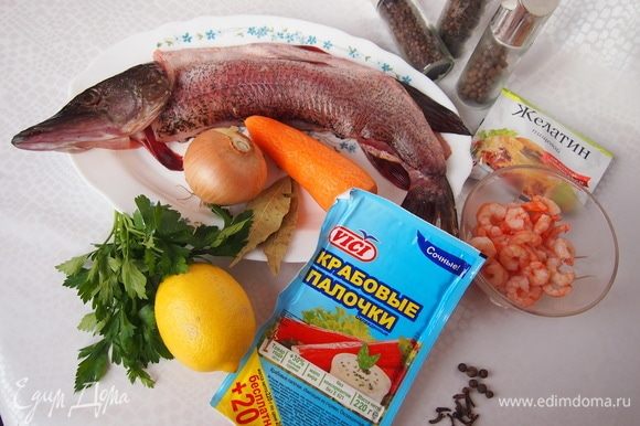 Подготовьте необходимые продукты. Рыбу отделить от костей и головы, подготовить филе с кожей. Морковь отварить. Крабовые палочки разрезать на 2-3 части. Лимон нарезать на тоненькие полукружочки.