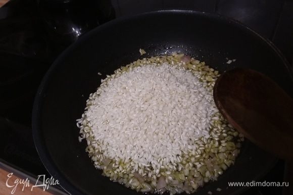 Выложить рис к луку, перемешать, обжарить коротко.