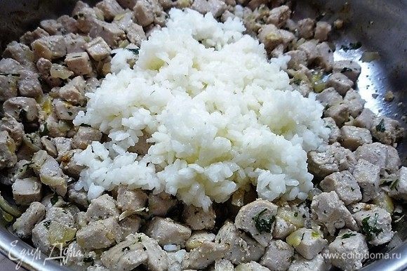 Добавляем отваренный рис, солим и перчим по вкусу, добавляем кардамон, рубленую зелень, перемешиваем и жарим 2-3 минуты.