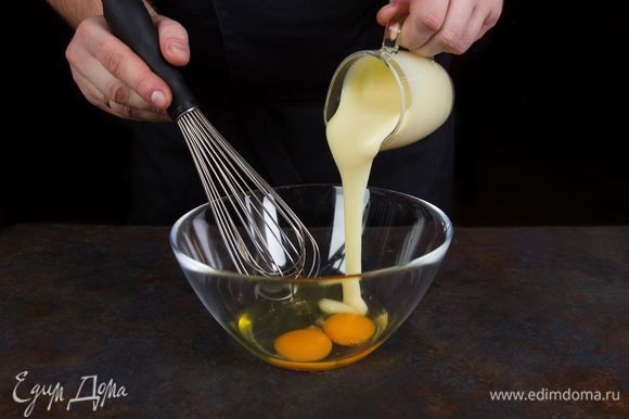 Приготовьте тесто для шарлотки. Для этого взбейте сгущенное молоко с яйцами.