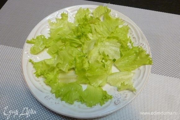 На сервировочной тарелке собираем салат. Листья салата порвем крупными кусками и разложим на тарелке.