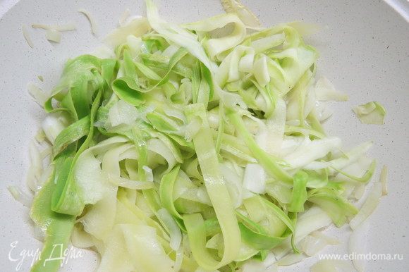 К луку добавляем нарезанные полосками кабачки, солим по вкусу, тушим овощи 5–7 минут. Кабачки должны уменьшиться в объеме примерно в 2 раза.