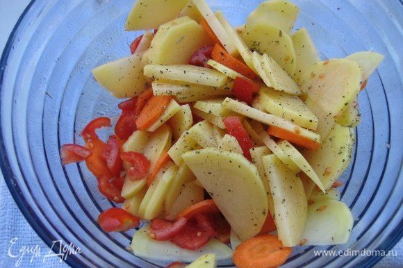Картофель и морковь почистить, тонко порезать, нарезать мелко помидоры, овощи посолить, поперчить, посыпать итальянскими травами, полить 2 ст. л. оливкового масла, перемешать.