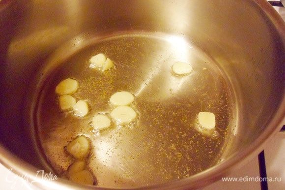 Приступить к приготовлению соуса: в кастрюлю с толстым дном налить оставшееся оливковое масло. Выложить чеснок, добавить щепотку молотого кориандра и жарить в течение 2 минут.