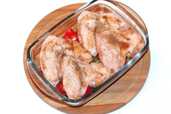 Сверху овощей выложить куриные крылышки и посыпать приправой для курицы 0,5 ч.л., посолить и поперчить. Накрываем формочку для запекания фольгой и отправляем в духовку на 40 минут или до готовности.