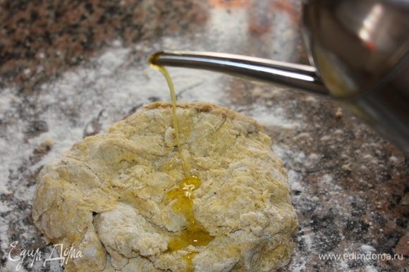 Выложить тесто на рабочую поверхность, присыпанную мукой, добавить 1 ст. ложку оливкового масла Extra Virgin.