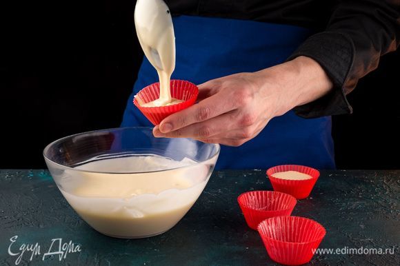 Смажьте сливочным маслом формочки для маффинов. Заполните их тестом на две трети.