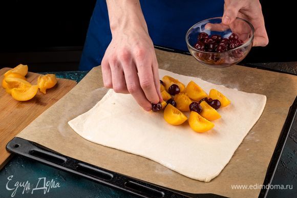 Раскатайте пласт слоеного теста переложите на застеленный пергаментом противень. Выложите фрукты на слой теста.