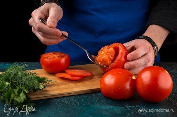 Срежьте шляпки у томатов. С помощью столовой ложки аккуратно удалите мякоть, стараясь не повредить целостность плодов.