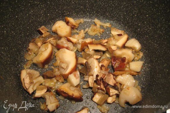 Лук-шалот мелко порезать, очистить зубчик чеснока, в глубокой широкой сковороде разогреть оливковое масло, потушить лук и чеснок, чеснок выкинуть. Размороженные белые грибы порезать, добавить вместе с сухими в сковороду, потушить 5 минут, помешивая.