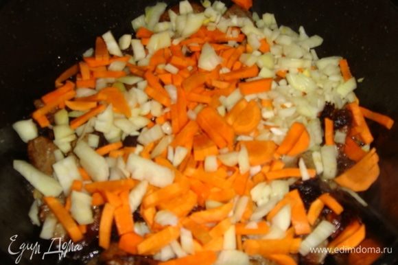 Лук нарезать кубиками, морковь — соломкой, добавить к мясу и слегка обжарить.