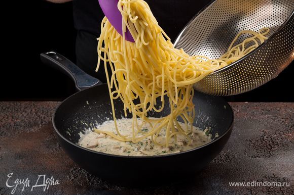 Выложите спагетти на сковороду к курице.