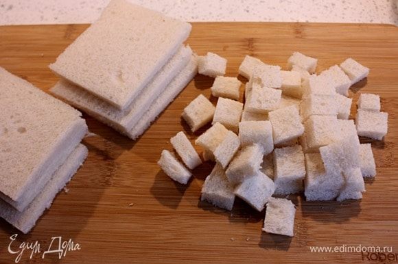 С ломтиков хлеба для тостов срезать корки и нарезать кубиками по 2,5 см.