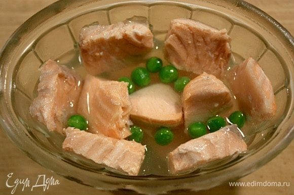 Налить слой бульона на 1 см выше креветок, охладить, а затем выложить кусочки рыбы, добавить горошек.
