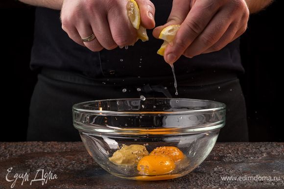 Отварите 5 небольших картофелин, яйца. Тем временем приготовьте домашний майонез. Соедините в миске 2 желтка, горчицу. Из лимона выжмите сок. Посолите, поперчите и разотрите венчиком.
