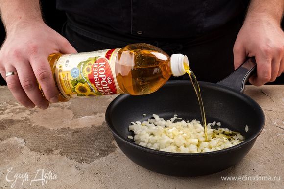В сковороду налейте нерафинированное подсолнечное масло ТМ «Корона изобилия», добавьте лук и обжарьте до полуготовности.