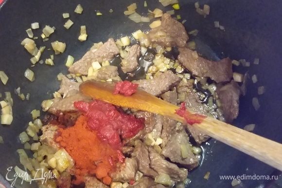 Добавить порошок сладкой красной паприки и томатную пасту, коротко обжарить.
