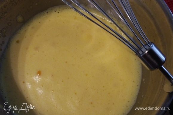 В большую миску поместить желтки и добавить 5 ст. л. теплой воды. Взбить до увеличения массы в объеме во много раз и консистенции пены. Добавить цедру апельсина.