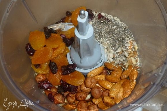 Духовку разогреть до 190°C. В комбайн сложить: орехи, семена, сухофрукты, специи и натереть цедру с апельсина. Измельчить.