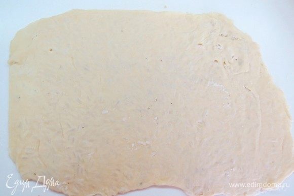 Складываем тесто пополам и раскатываем скалкой пласт толщиной 2–3 мм. На тесте будет виден рисовый рельеф.