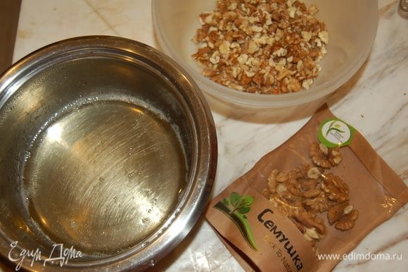 Для хрустящих орешков следует вначале сварить сироп. Смешать воду, сахар и мед. Довести до кипения и вылить на поломанные орешки. Перемешать и выложить на противень. Готовить до золотистого цвета около 15 минут на 140°С.