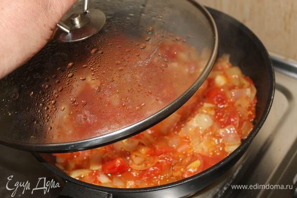Далее добавьте к луку нарезанные помидоры и тушите овощи под крышкой.