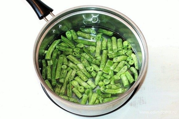 Подготовим овощи. В кипящую подсоленную воду положите стручковую фасоль. Варите 5–7 минут до готовности. Затем воду слейте, фасоль охладите.