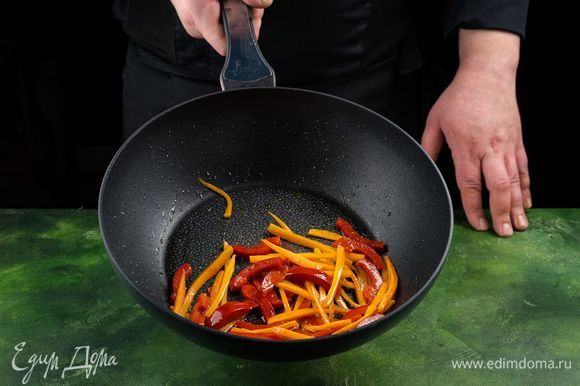 Смажьте сковороду оливковым маслом и обжарьте перец и морковь на сильном огне в течение минуты.