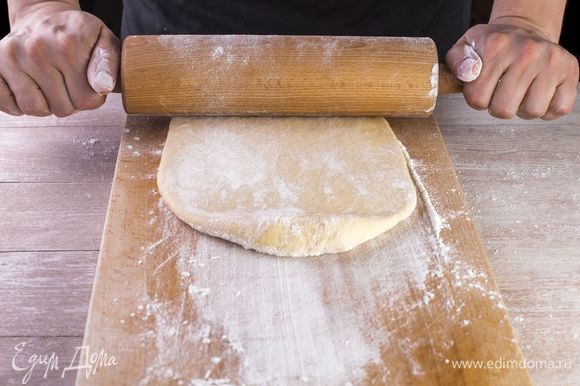 Разделите тесто на несколько частей, раскатайте скалкой в продолговатые пласты по ширине чуть больше, чем сосиска.