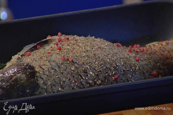 Один лавровый лист и половину тимьяна поместить в брюшко карпа, оставшийся лавровый лист и веточки тимьяна разложить вокруг рыбы, посыпать ее внутри и снаружи специями.