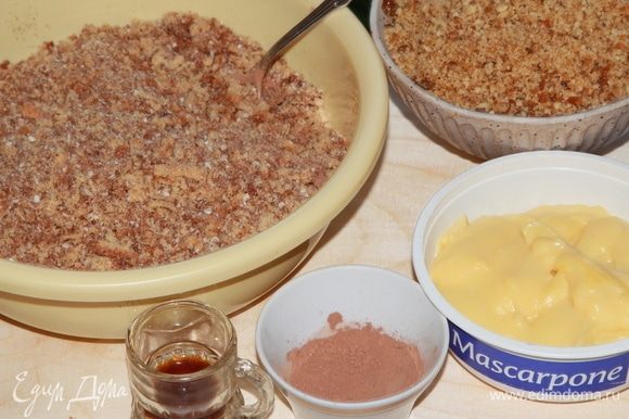 Подготовьте все необходимые ингредиенты для сборки пирожного: бисквитную крошку, грильяж, заварной крем, какао-порошок и коньяк.