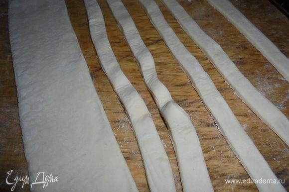 Слоеное тесто раскатать в одном направлении и нарезать на полоски шириной примерно 1 см.