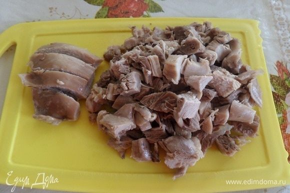 Отваренное куриное мясо вынимаем из кастрюли, слегка остужаем и нарезаем кубиком.